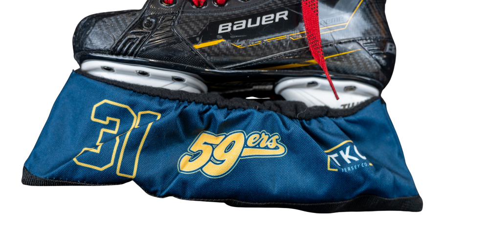 A black and gray Bauer hockey skate boot with red laces resting on a blue and gold San Francisco 49ers team boot cover featuring the number 31 and team logo.